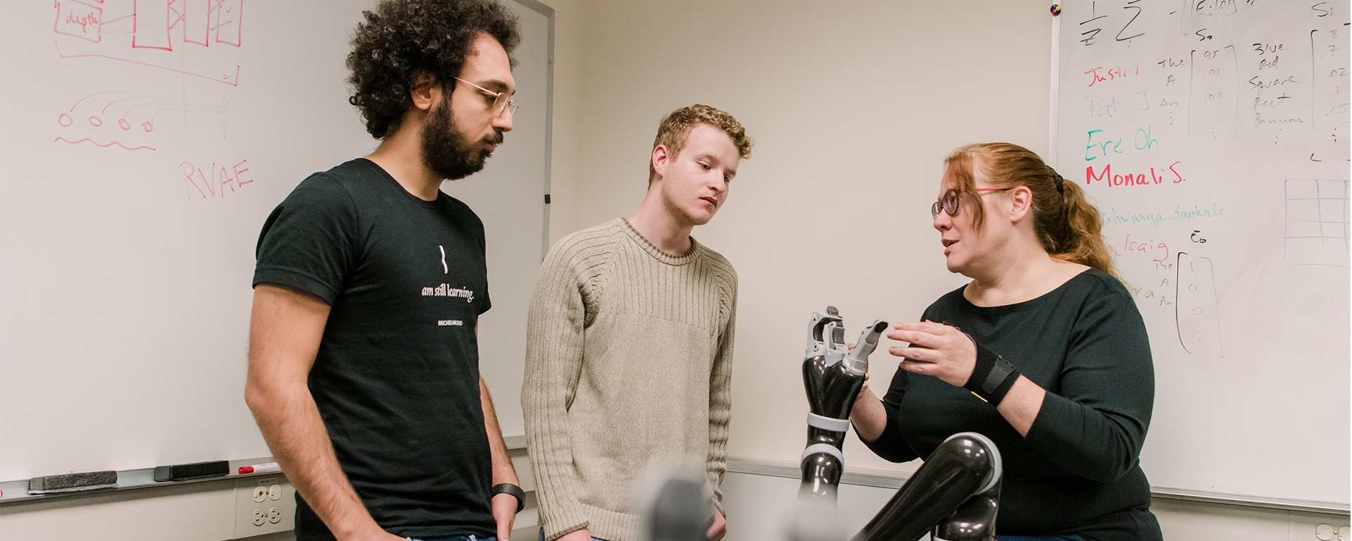 three people in lab with robot